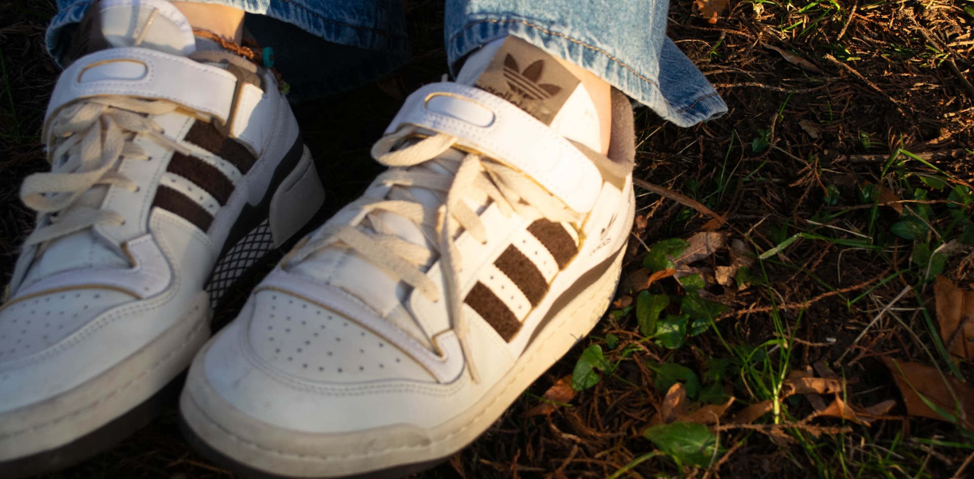 a person's feet wearing white and brown sneakers